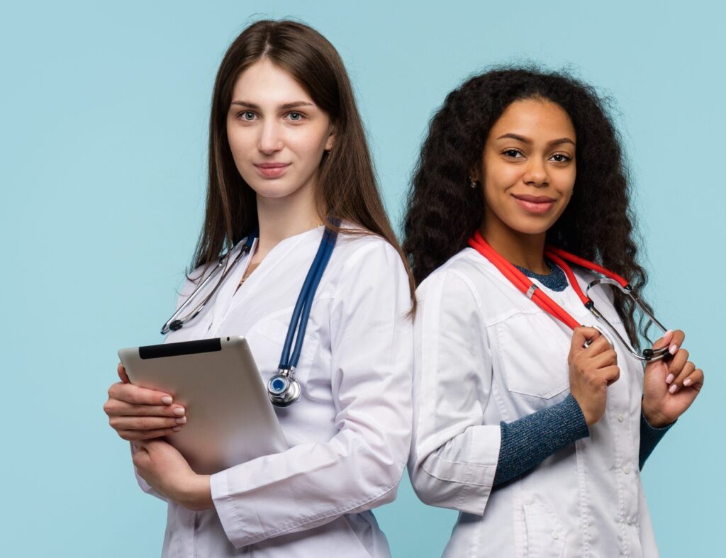 Two doctors are standing side by side holding stethoscopes.